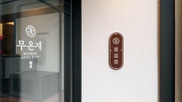 Un letrero de hotel con texto coreano y un logotipo.