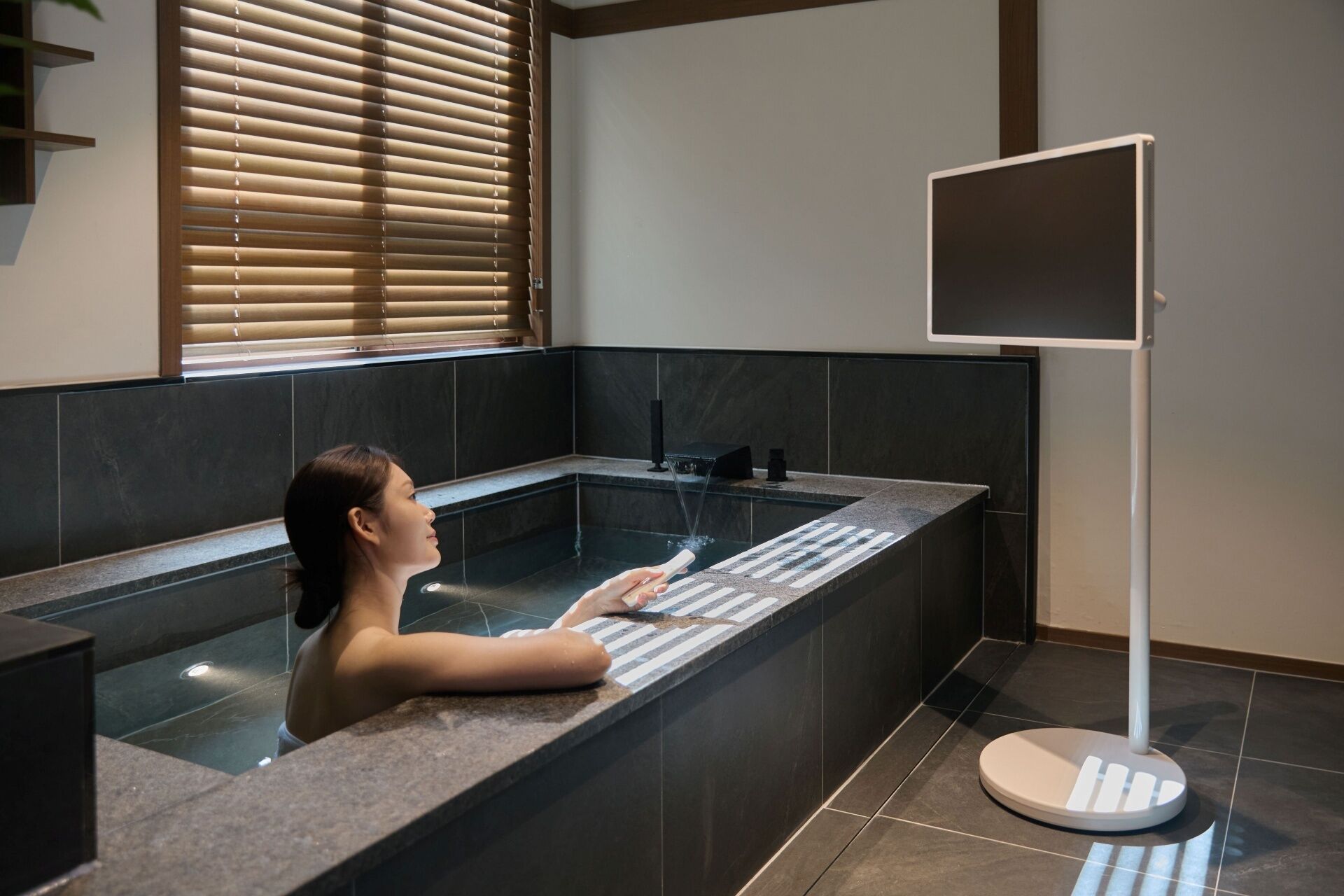 A person in a bathtub with a digital screen.