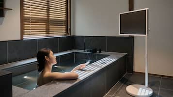 A person in a bathtub with a digital screen.