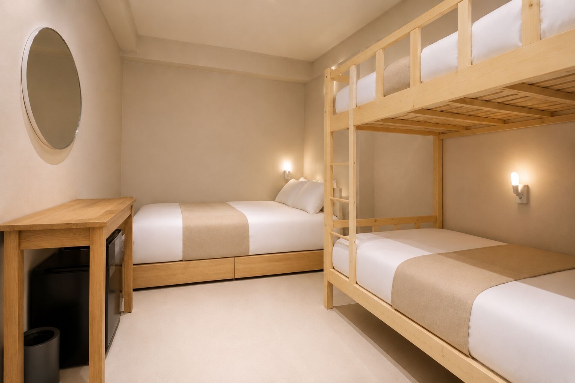 A room with bunk beds, a desk, and a trash bin.