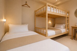 Habitación con literas de madera, una mesita de noche y un aplique en la pared.