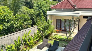 Una propiedad residencial con piscina, sillas de descanso y techo de tejas rojas.
