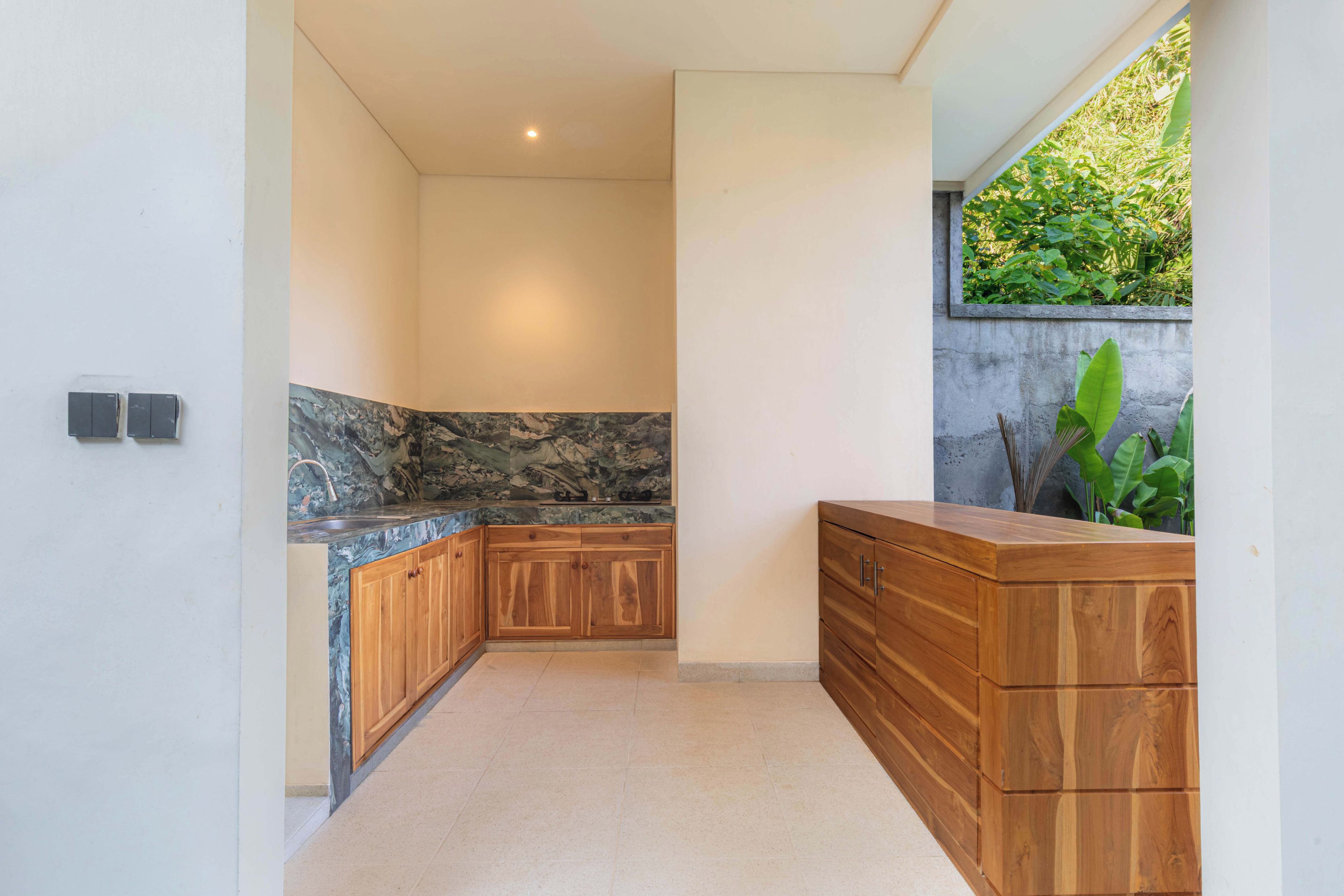 A modern kitchen with a marble backsplash, wooden cabinets, and a built-in sink.
