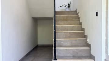 Una escalera con barandilla negra que conduce a una plataforma.