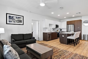 Eine moderne Wohnung mit Wohnzimmer, Küchenzeile und Essbereich.