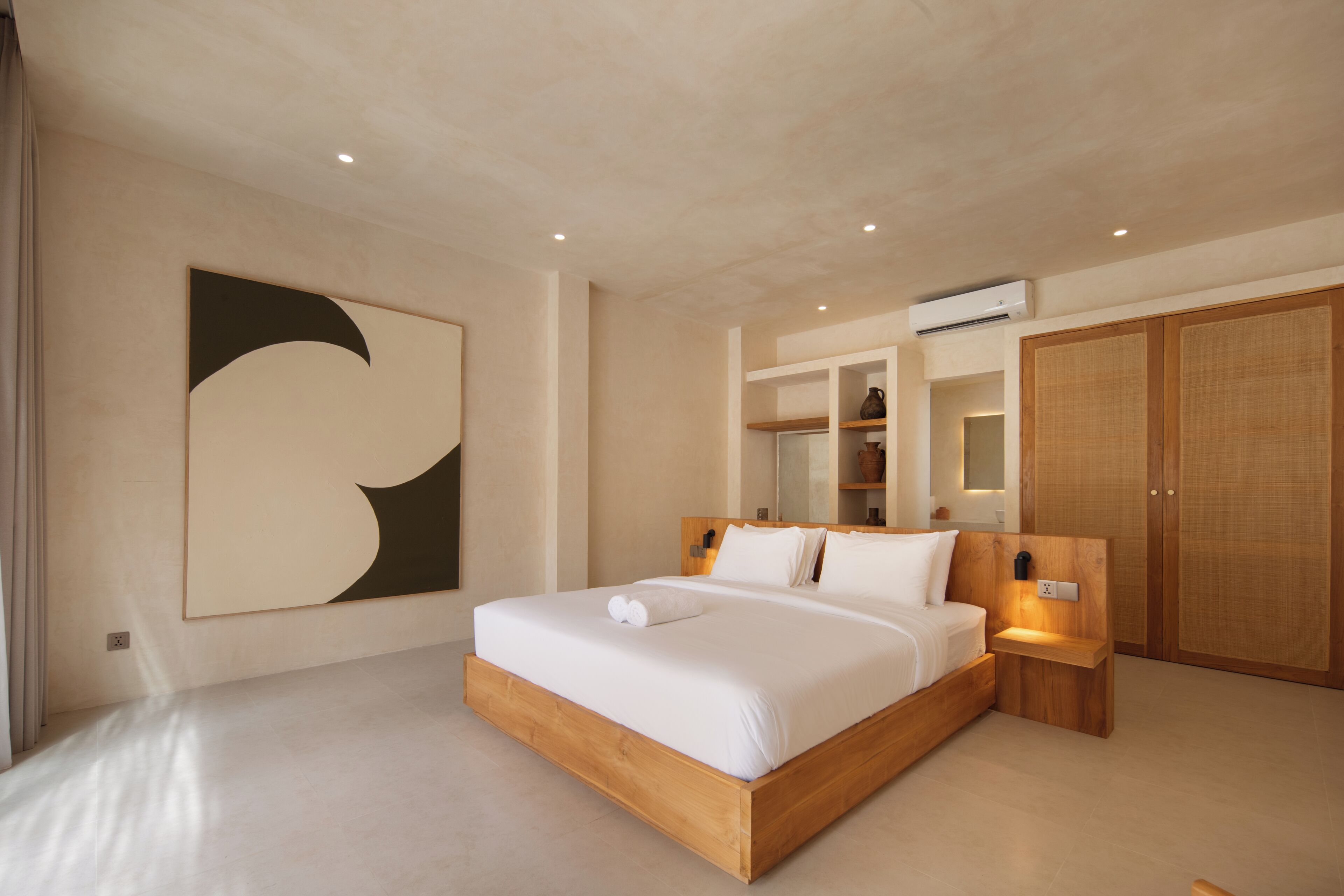 A modern bedroom with a large bed, built-in shelves, and a wardrobe.