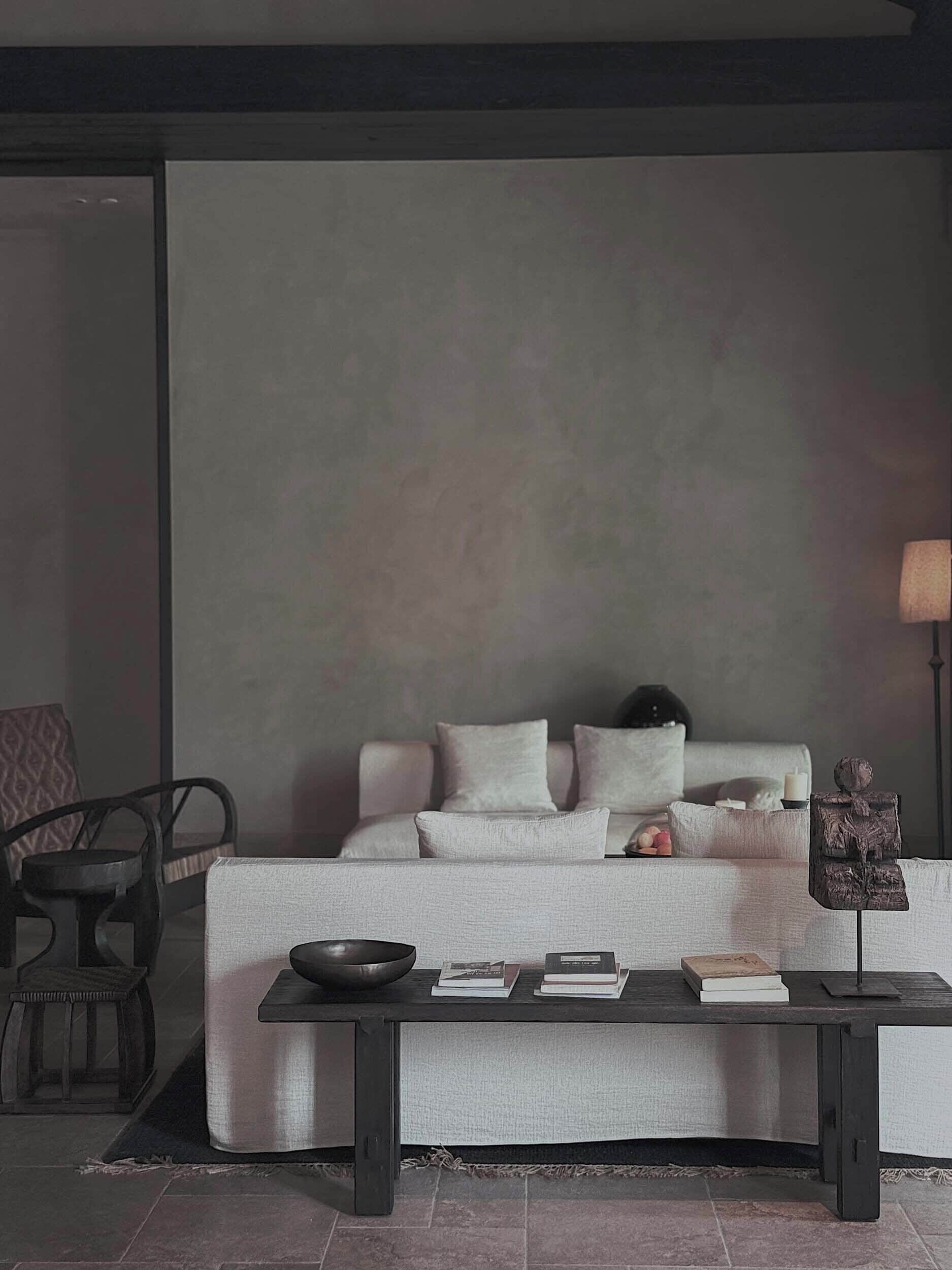 A minimalist living room with a sofa, a coffee table, and a lamp.