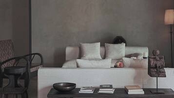 A minimalist living room with a sofa, a coffee table, and a lamp.