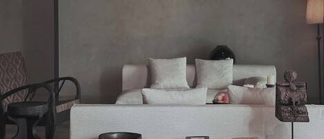 Una sala de estar minimalista con un sofá, una mesa de centro y una lámpara.