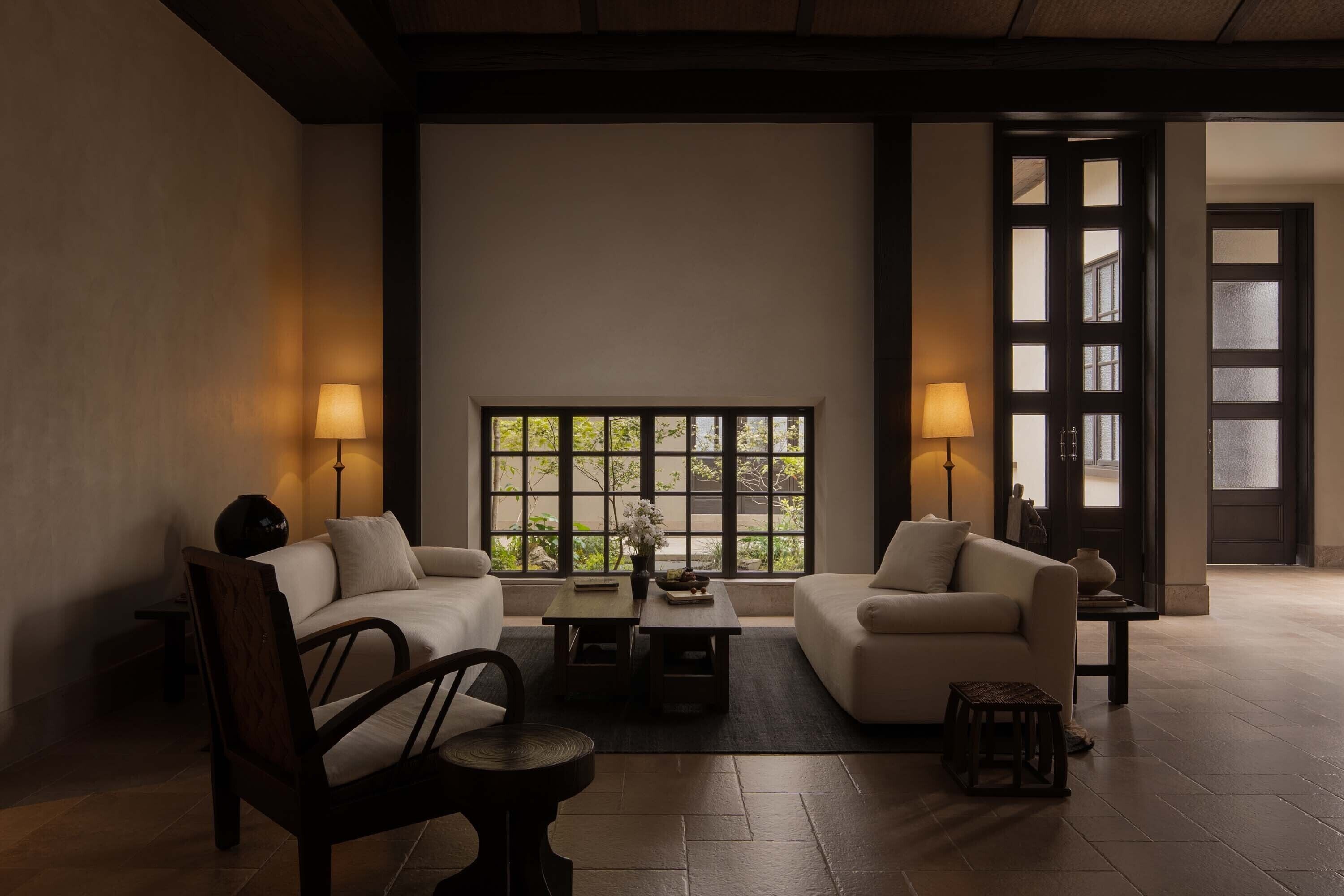 A modern living room with two sofas, a coffee table, and two floor lamps.