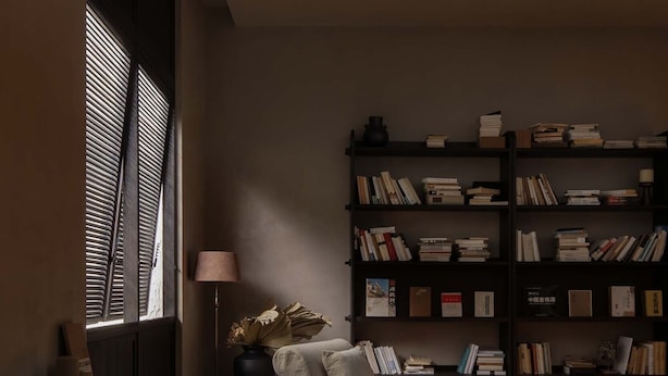 A cozy living room with a fireplace, a bookshelf, and a comfortable armchair.