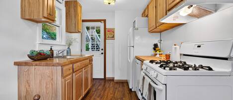 A kitchen with wooden cabinets, a white stove, and a refrigerator.