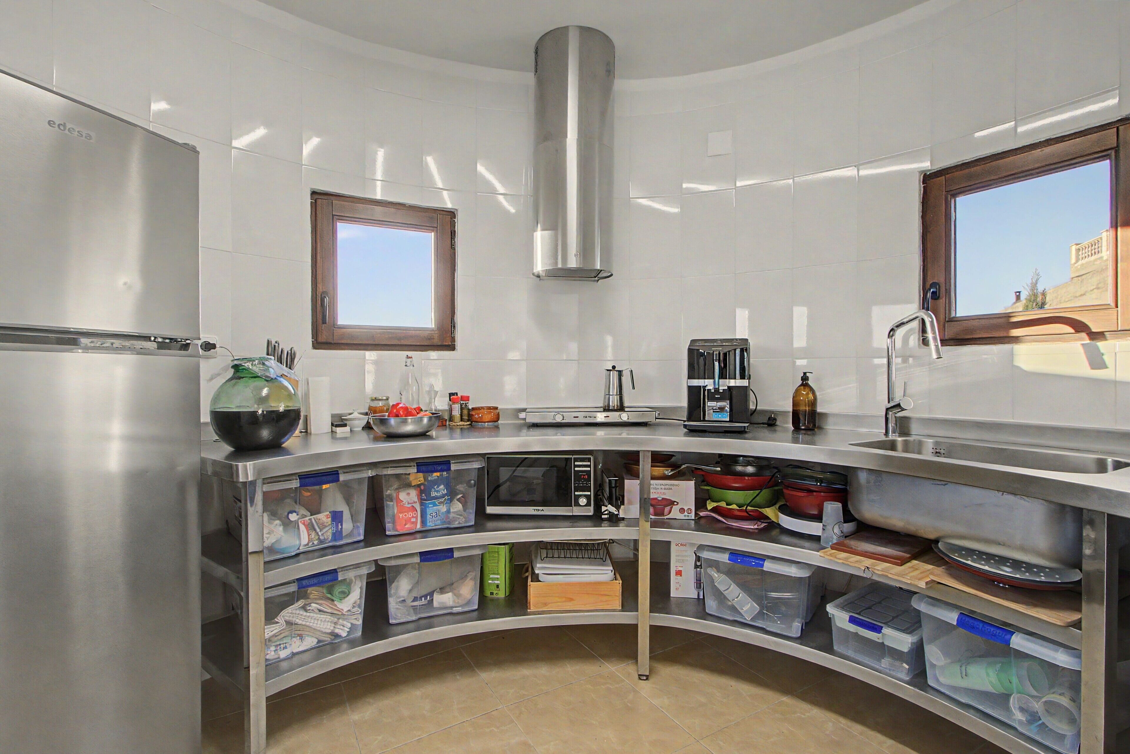 Een moderne keuken met roestvrijstalen apparatuur, een inbouwoven en een raam.
