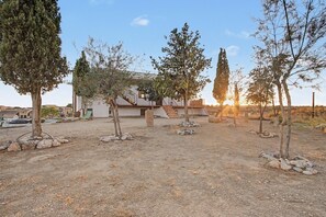 A residential area with a white house, a dirt driveway, and several trees. - Holiday Home 'Castell De Menàrguens' with Private Terrace, Private Garden and Wi-Fi (Menàrguens)