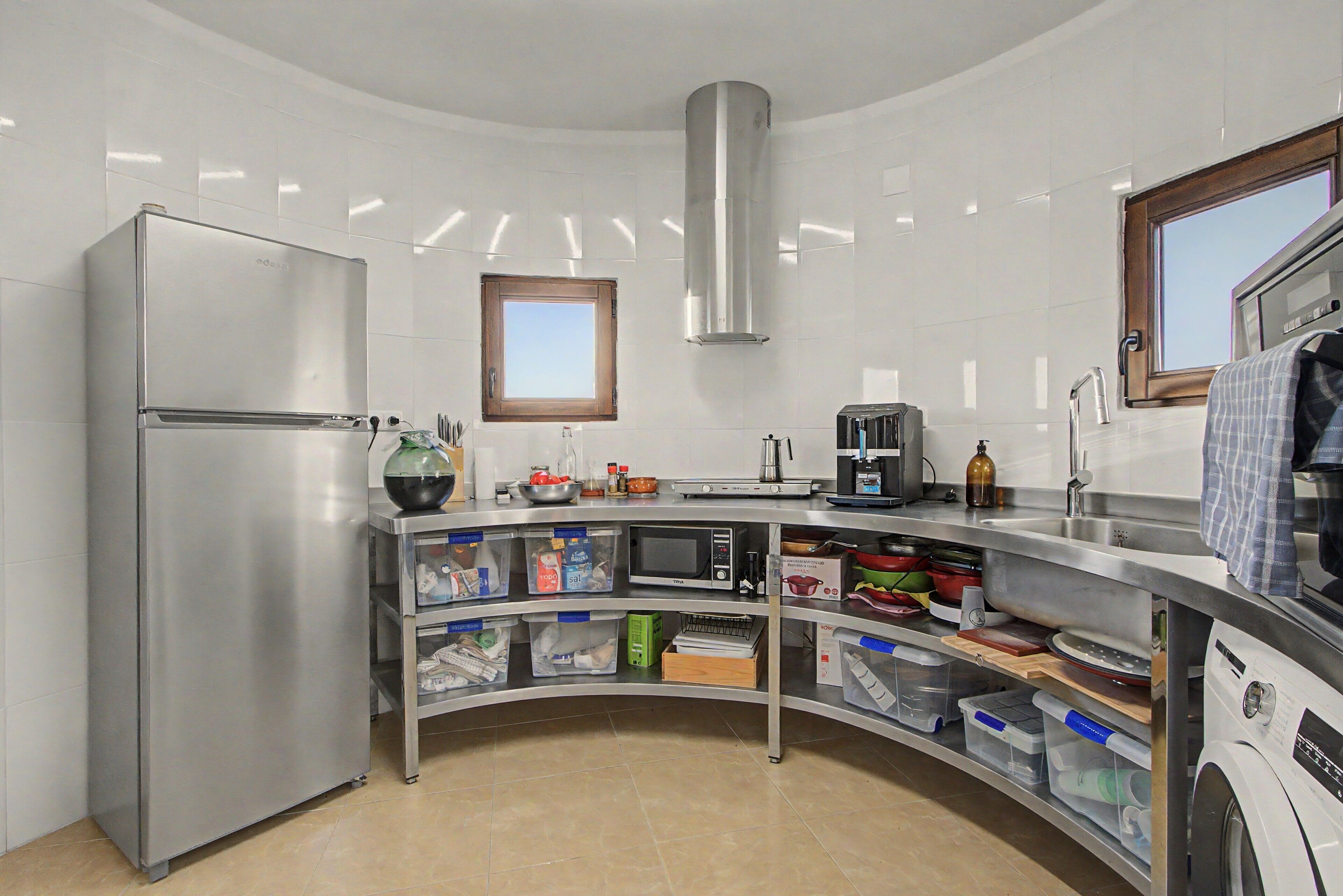 A modern kitchen with a built-in oven, a microwave, and a stainless steel sink.