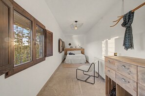 A narrow hallway leading to a bedroom with a bed, a chair, a dresser, and a radiator. - Holiday Home 'Castell De Menàrguens' with Private Terrace, Private Garden and Wi-Fi (Menàrguens)