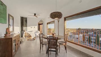 A spacious dining area with a view of the cityscape through large windows.