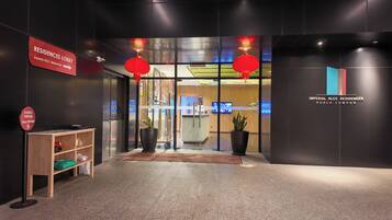 The entrance to Imperial KLCC Residences with a reception desk, a sign indicating the lobby, and a drop-off point for food and parcels.
