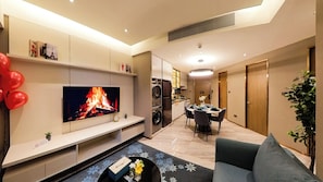 A modern living room with a flat-screen TV, a dining area, and a kitchen. - Imperial Residence KLCC- JD Home (Wilayah Persekutuan)