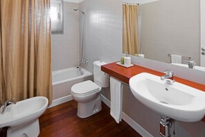 A bathroom with a bathtub, toilet, bidet, and two sinks. - Casas Bioclimáticas Iter El Muro (Granadilla de Abona)