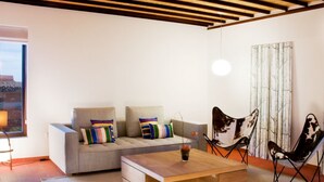 A modern living room with a sofa, a coffee table, and a chair. - Casas Bioclimáticas Iter El Cubo (Granadilla de Abona)