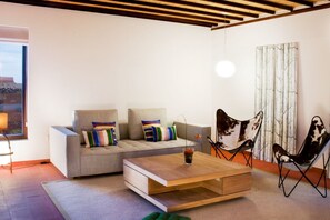 A modern living room with a sofa, a coffee table, and a chair. - Casas Bioclimáticas Iter El Cubo (Granadilla de Abona)