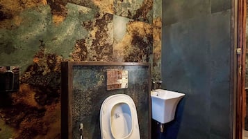 A bathroom with a toilet, a sink, and a shower.