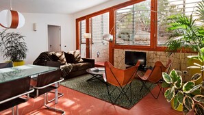 A living room with a sofa, chairs, a TV, and a dining area with a table and chairs. - Casas Bioclimáticas Iter La Estrella (Granadilla de Abona)