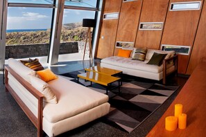 Ein modernes Wohnzimmer mit einer Couch, einem Couchtisch und Blick auf die Landschaft.