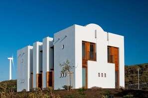 A modern building with a flat roof, rectangular windows, and a small balcony. - Casas Bioclimáticas Iter Casa Bernouilli (Granadilla de Abona)
