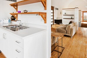 A modern kitchen with white cabinetry and a wooden ceiling structure. - Casas Bioclimáticas Iter Casa Bernouilli (Granadilla de Abona)