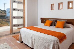 A bedroom with a bed, a window, and a view of the outside. - Casas Bioclimáticas Iter Casa Bernouilli (Granadilla de Abona)