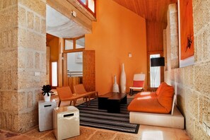 Un salon moderne avec un mur en pierre, un canapé, une table basse et un fauteuil.
