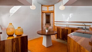 Moderni keittiö, jossa on keskeinen saareke, puiset kaapit ja näkymä ruokailutilaan.