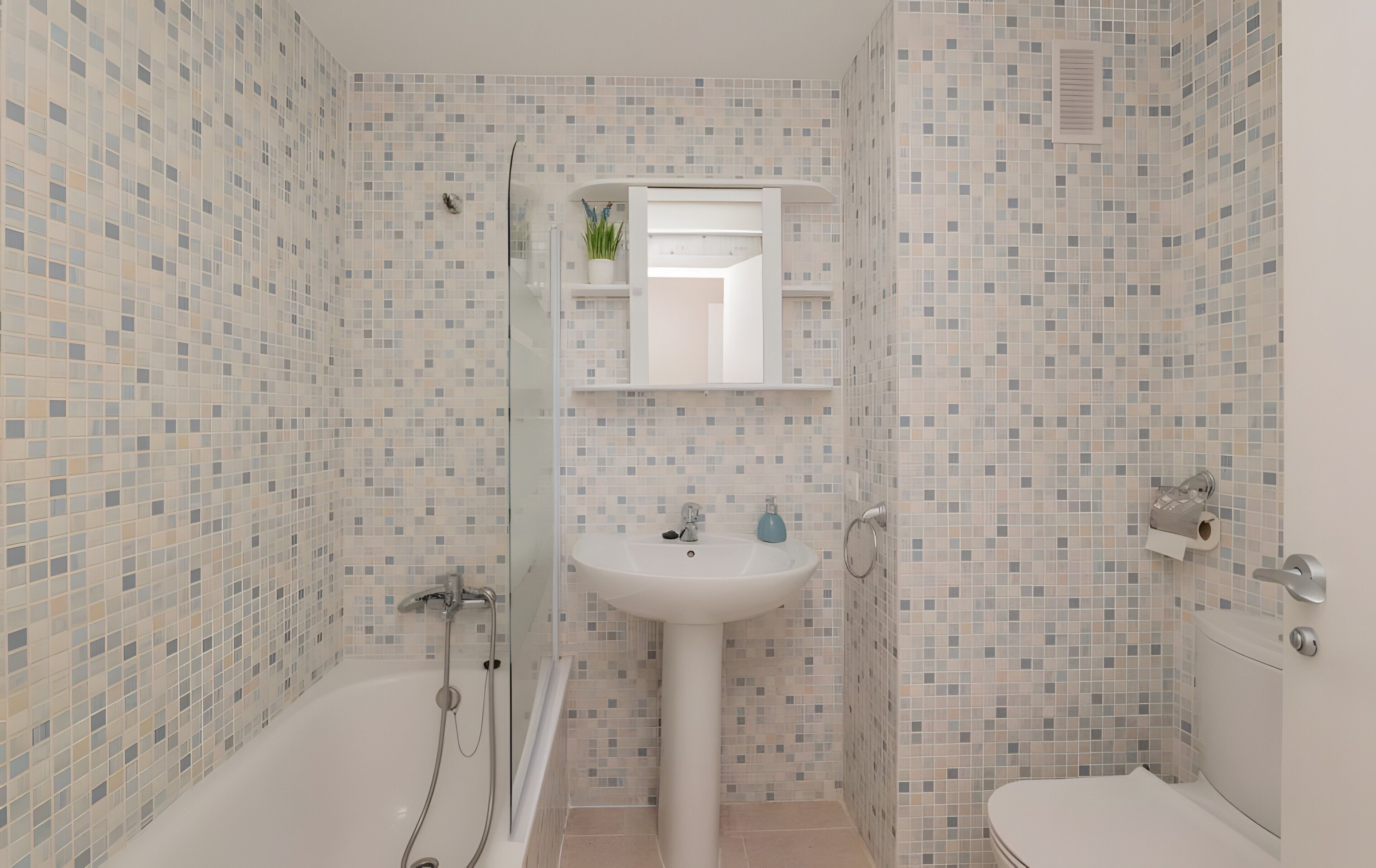 Een badkamer met een bad, wastafel en toilet.