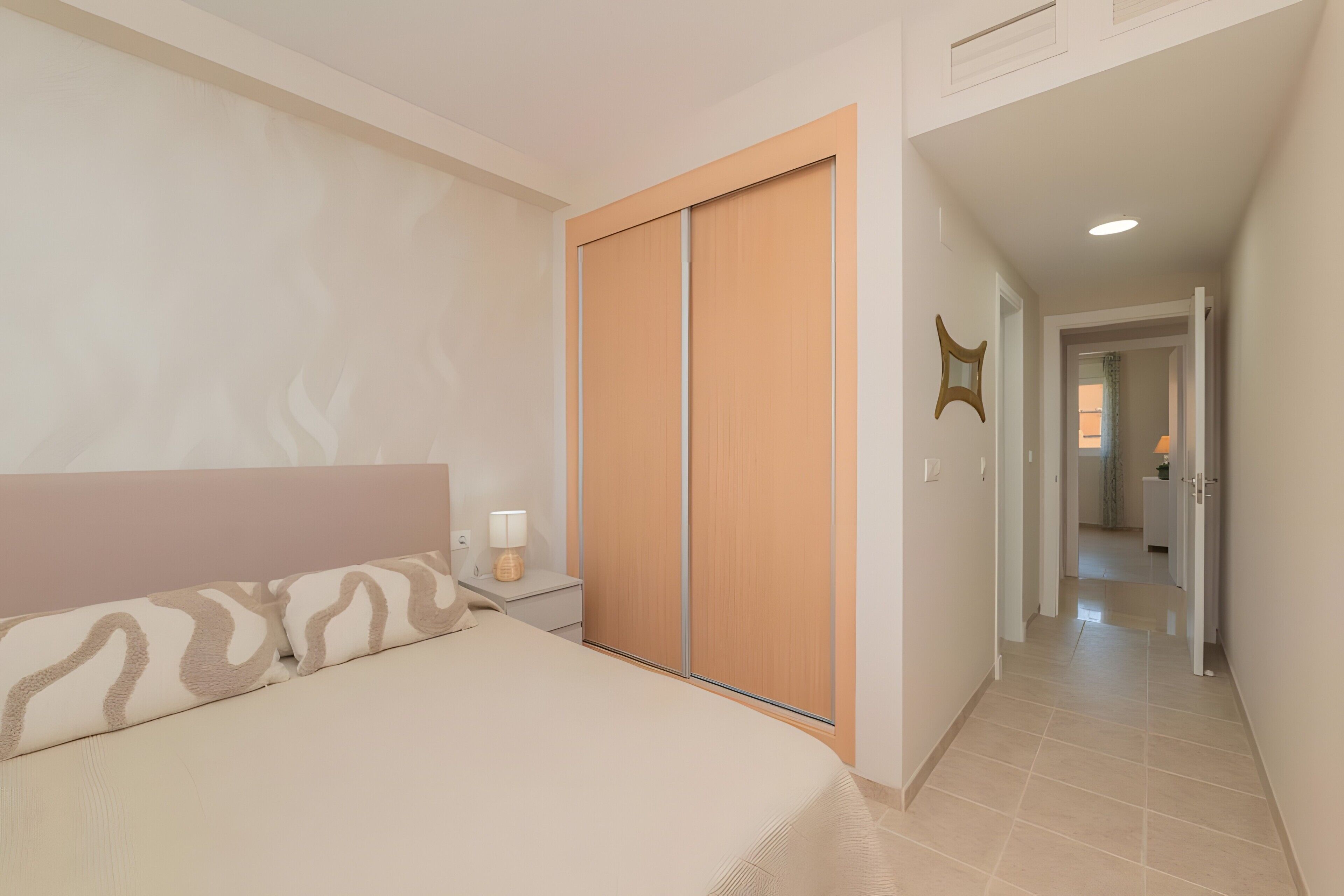 A bedroom with a bed, nightstand, and a wardrobe.