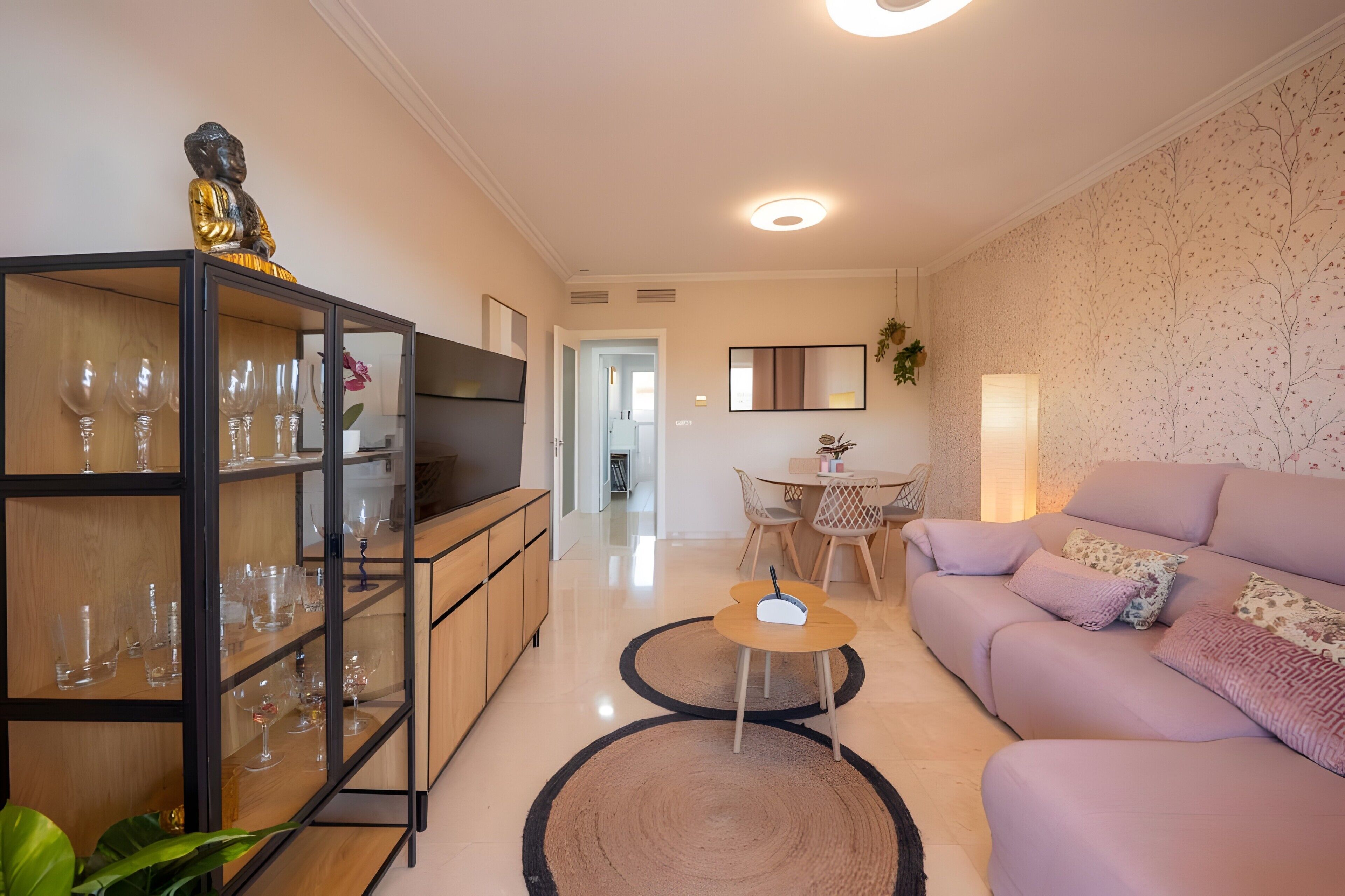 A modern living room with a sofa, a coffee table, and a TV on a cabinet.