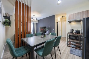 A modern kitchen with a dining area, featuring a wooden partition, a built-in microwave, and a stainless steel refrigerator. - Fully Furnished 2-Bedroom Condo in Cebu IT Park Near Sugbo Mercado & Ayala Mall (Cebu City)