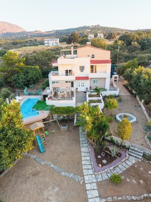 Ein mehrstöckiges Haus mit Schwimmbad, Außenbereich und Garten.