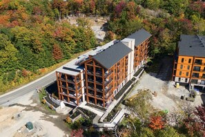Un immeuble à plusieurs étages doté d’une architecture moderne, avec des balcons et une cour intérieure.