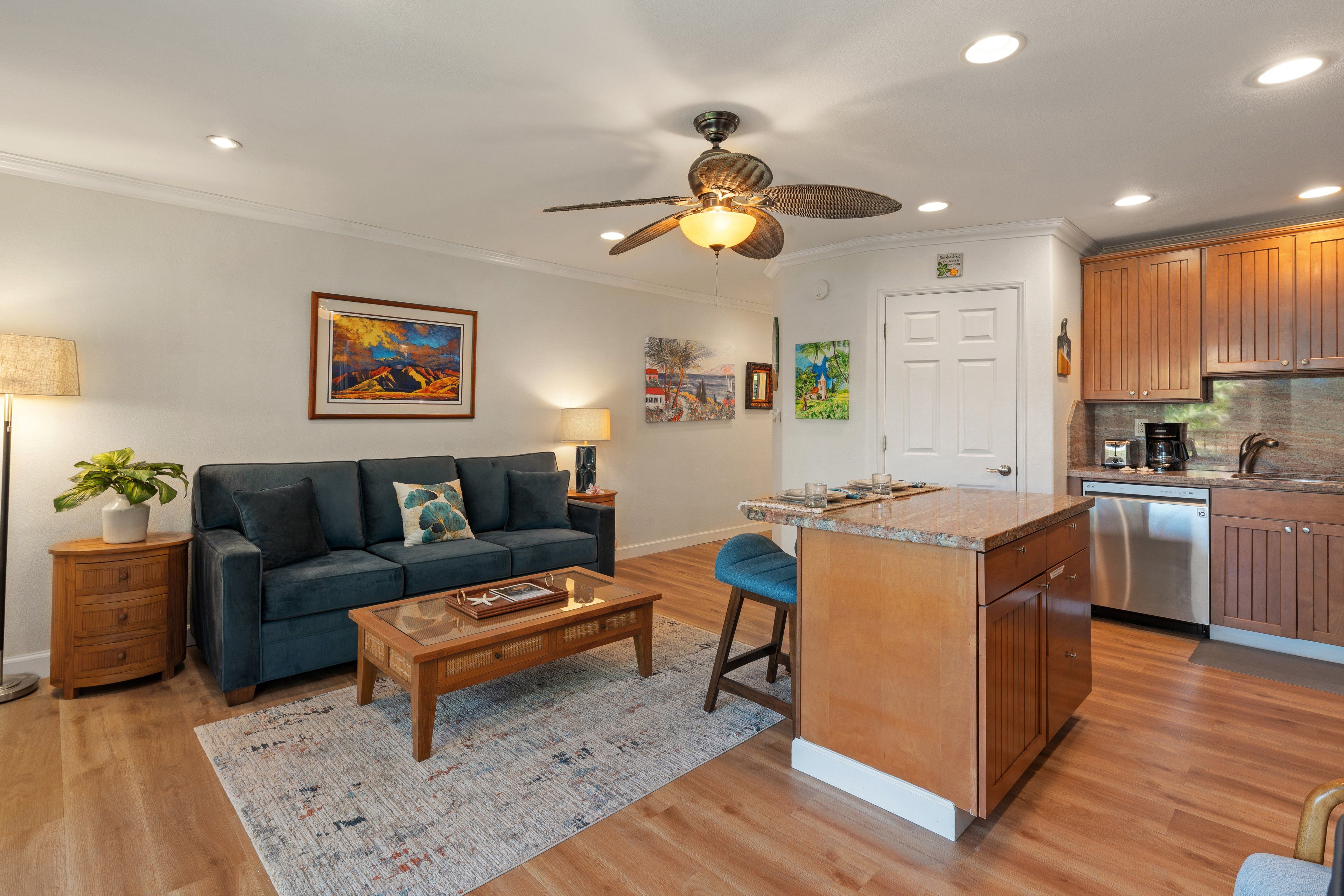 A modern living room with a sofa, coffee table, and artwork on the wall.
