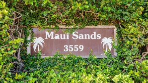 Una señal con el texto 'Maui Sands 3559' rodeada de vegetación densa.