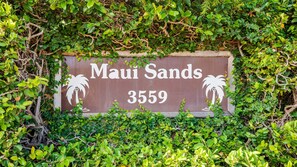 A sign with the text 'Maui Sands 3559' surrounded by dense greenery. - Garden View Condo Just Steps from the Ocean -Maui Sands Seaside 717 (Lahaina)