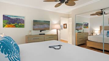 Een hotelkamer met een bed, een dressoir, een spiegel, een televisie en kunstwerken aan de muren.