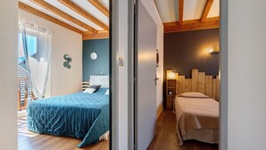 A bedroom with a bed, bedside table, and a wall-mounted clock.