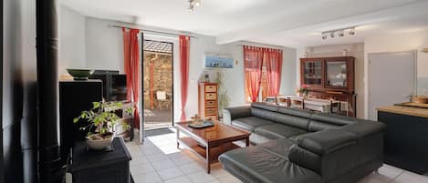 Una sala de estar con sofá, una mesa de centro, televisor y chimenea.
