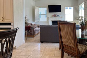 Ein Wohnzimmer mit einer Couch, einem Fernseher und einem Kamin.