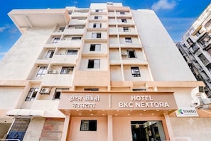 A multi-story hotel with a sign indicating 'HOTEL BKC NEXTORA' and a logo for 'treebo'.