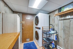 A laundry room with a washing machine, dryer, and a shelf with cleaning supplies. - Ashland Home w/ Deck - Blueberry Overlook (Ashland)