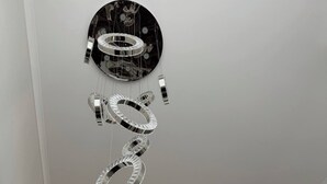 A modern interior with a reflective ceiling fixture and a glass railing.